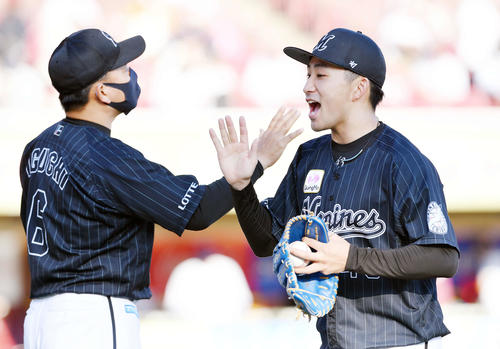 楽天対ロッテ　完封勝ちしロッテ井口監督（左）とタッチを交わす小島（撮影・滝沢徹郎）