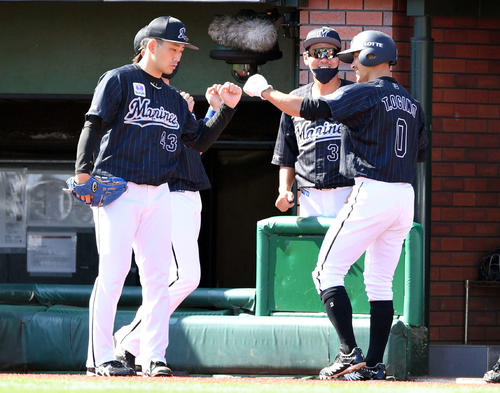 楽天対ロッテ　1回表ロッテ1死一、二塁、レアードの先制の適時二塁打から生還した二走荻野（右）とタッチを交わす小島（撮影・滝沢徹郎）