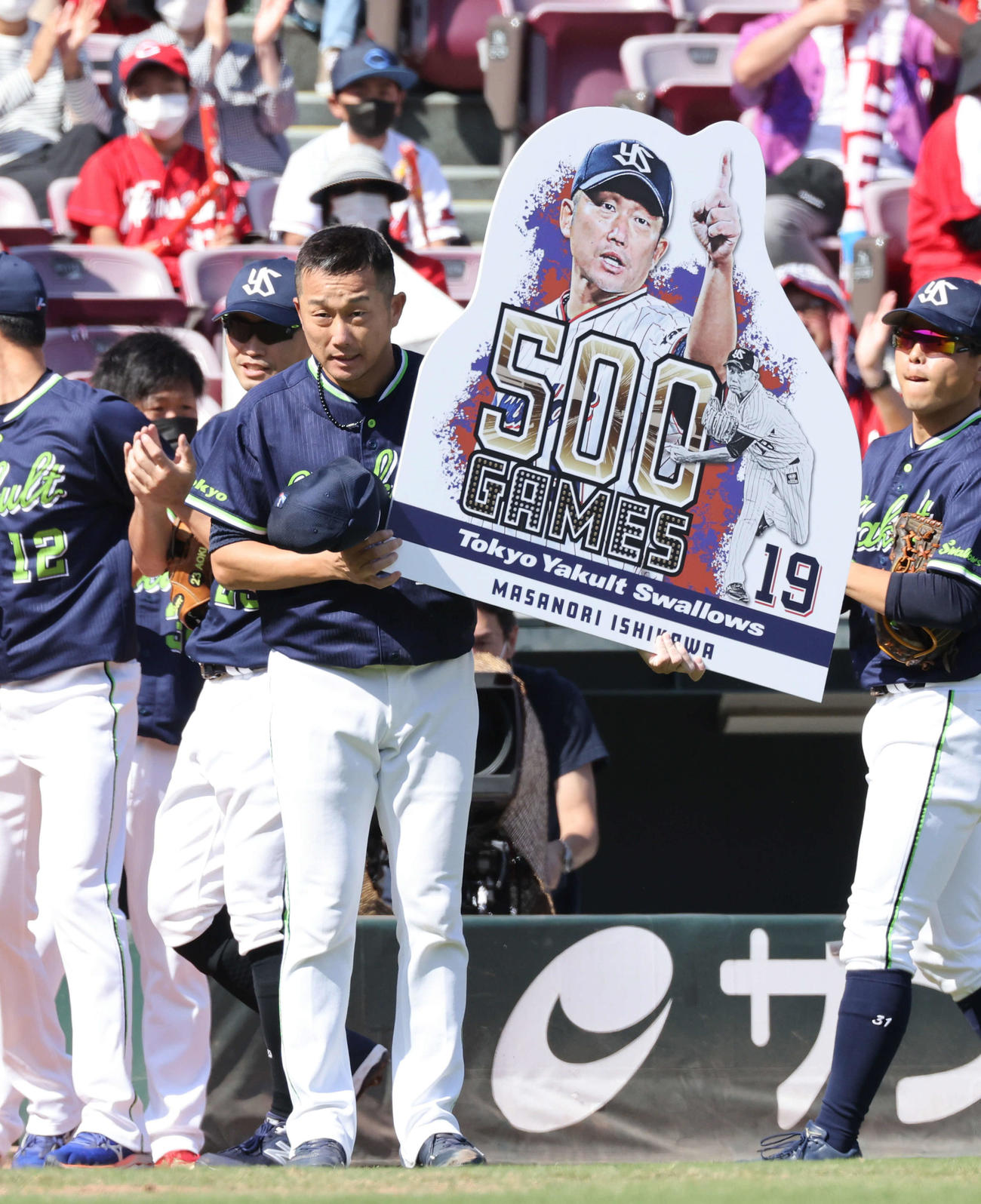 広島対ヤクルト　500試合登板のボードを掲げるヤクルト先発の石川（撮影・加藤孝規）