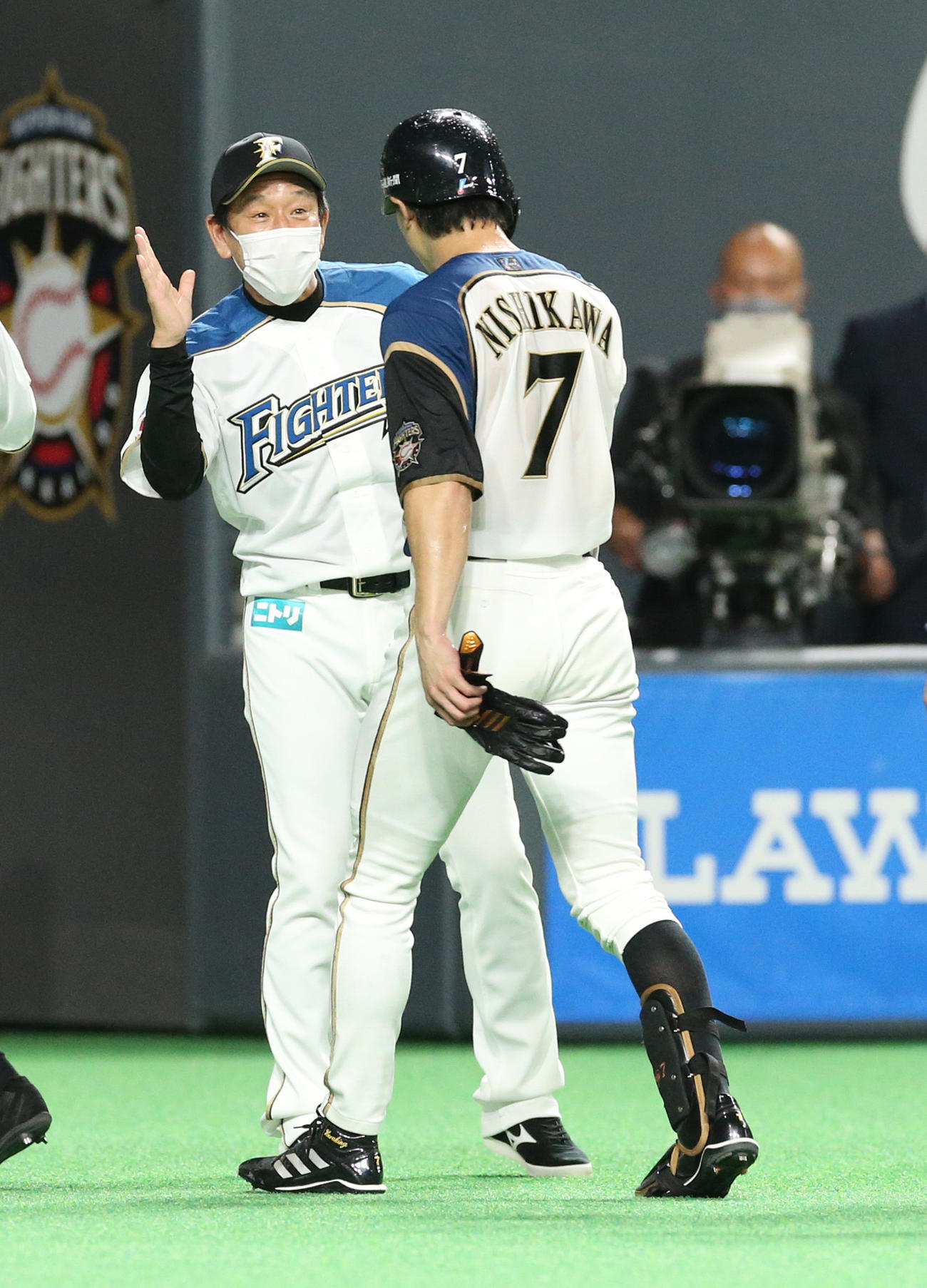 日本ハム対西武　日本ハム栗山監督（左奥）はサヨナラ適時打を放った西川を笑顔で出迎える（撮影・佐藤翔太）