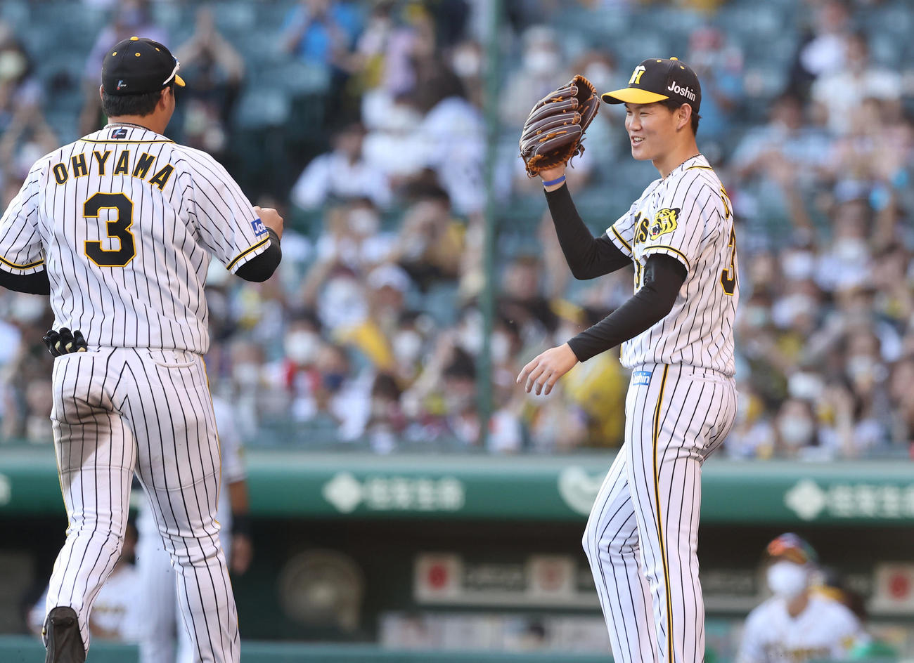 阪神対中日　7回表、ピンチをしのぎ笑顔で阪神大山（左）とグラブでタッチを交わす及川（撮影・前田充）