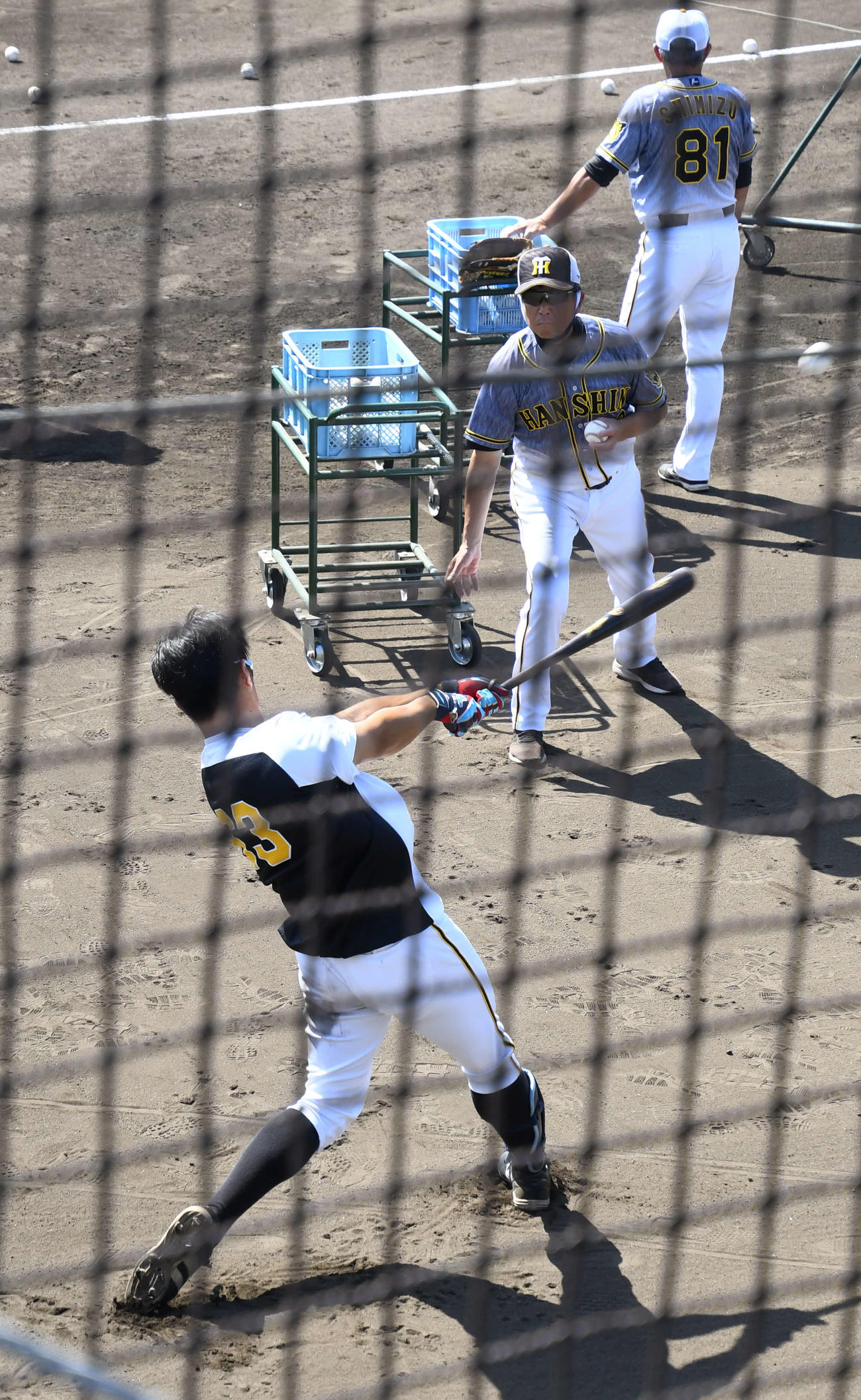 2軍練習試合オリックス対阪神　試合前にロングティーに励む阪神板山（手前）とトスを上げる平田2軍監督（撮影・中野椋）