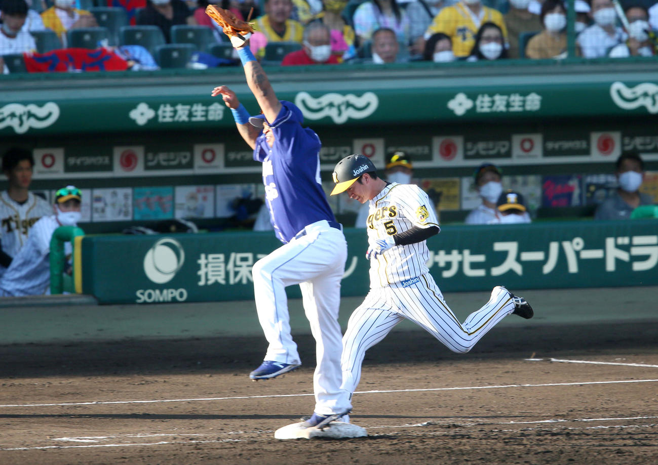 阪神対中日　7回表阪神1死、近本は遊内野安打を放つ。手前は一塁手ビシエド（撮影・上山淳一）