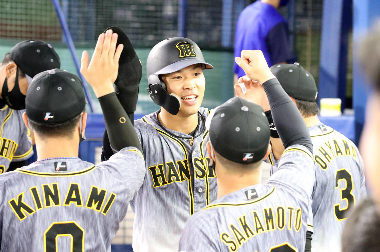 DeNA対阪神　1回表阪神攻撃終了、右前適時打を放った佐藤輝は、ナインの祝福に笑顔で応える（撮影・加藤哉）
