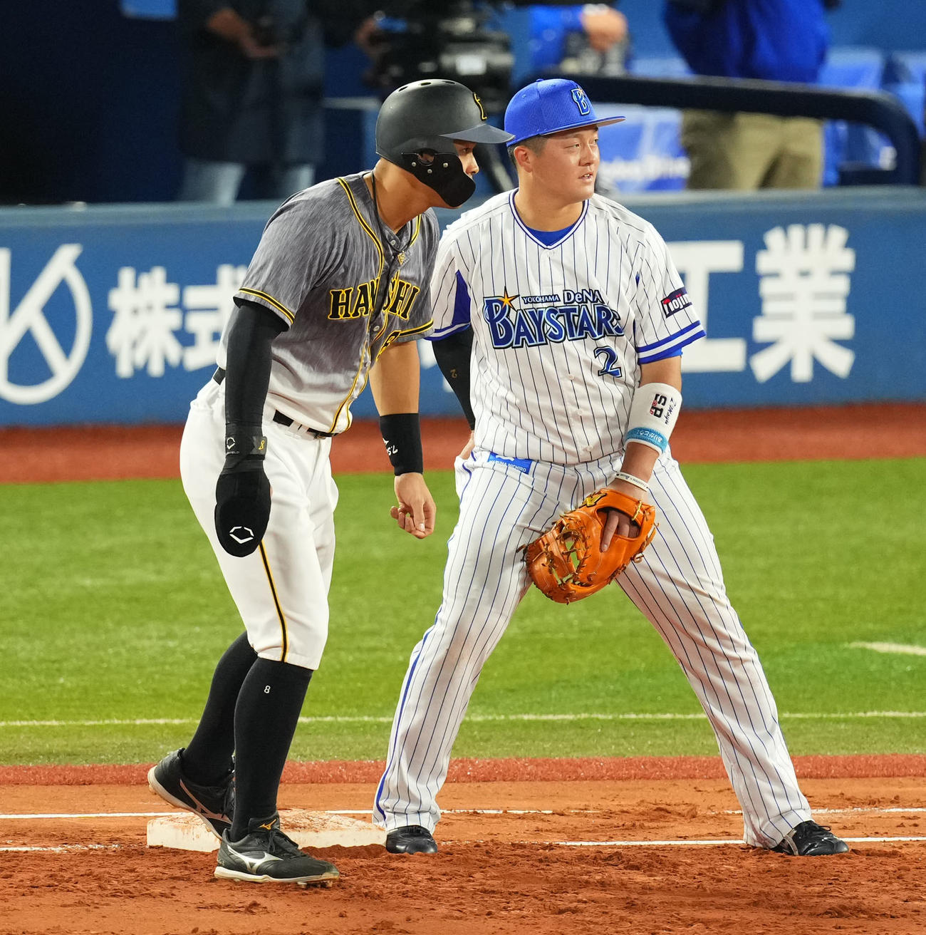 DeNA対阪神　1回表阪神2死一、三塁、塁上で言葉を交わす阪神佐藤輝（左）とDeNA牧（撮影・横山健太）