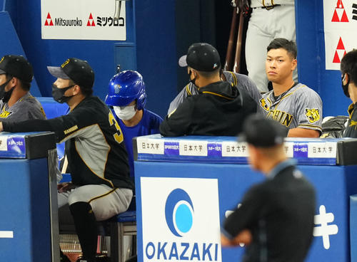 DeNA対阪神 8回表阪神無死二塁、代打を送られた佐藤輝(右)は悔しげな表情でスコアを見つめる(撮影・横山健太)
