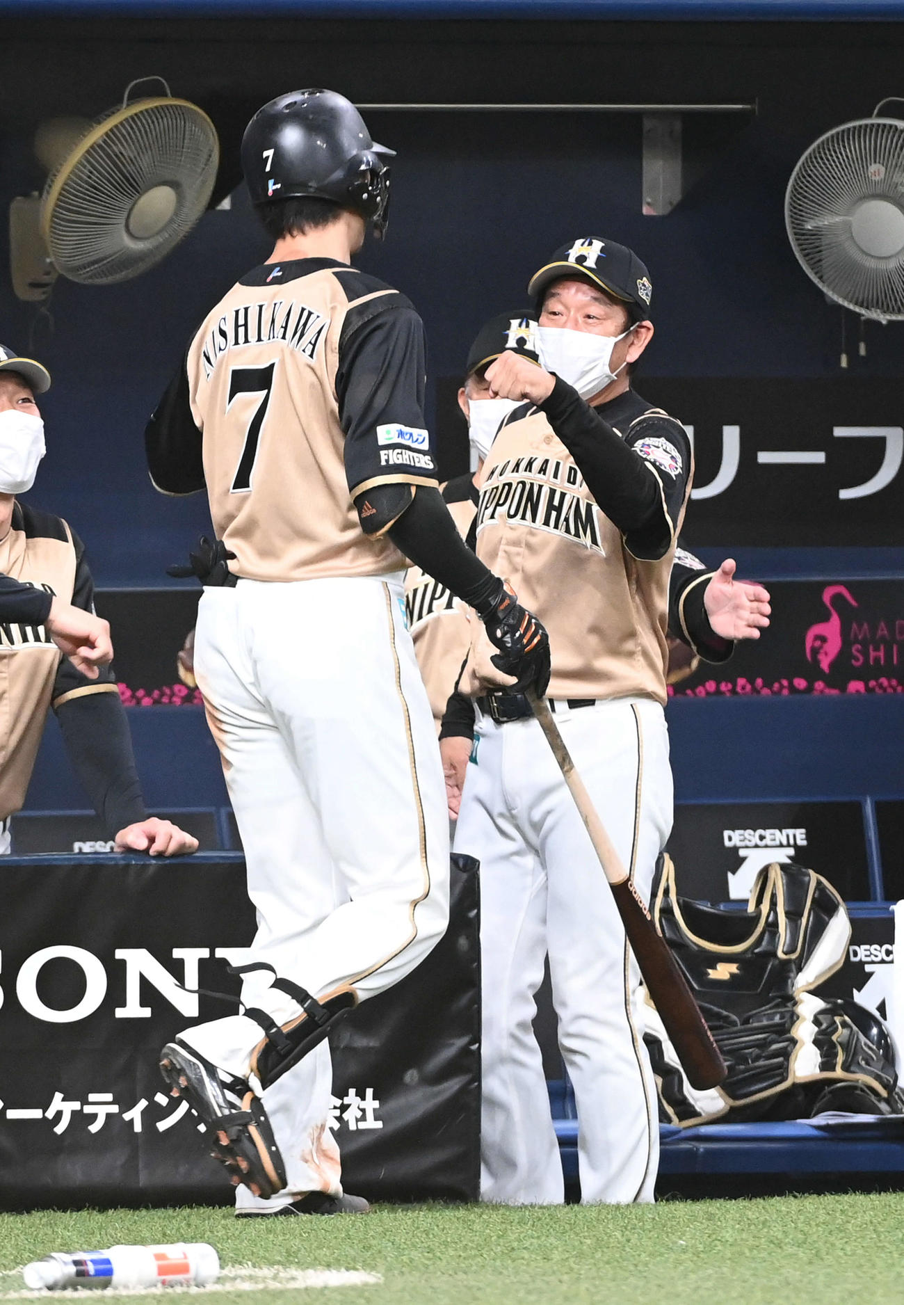 オリックス対日本ハム　7回表日本ハム1死一、三塁、中犠飛を放った西川（左）を迎える栗山監督（撮影・前岡正明）