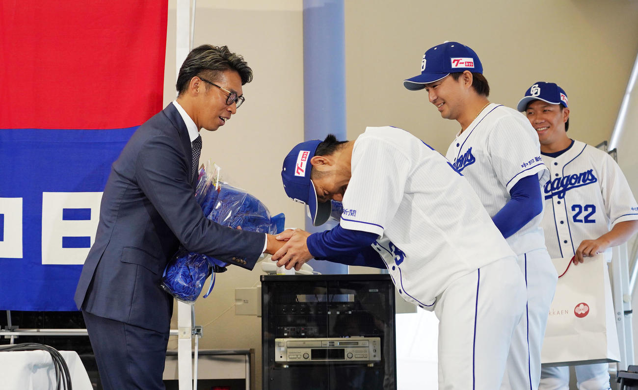 引退会見後、（右から）大野雄、田島、祖父江から花束を受け取り握手をかわす山井（左）（撮影・森本幸一）