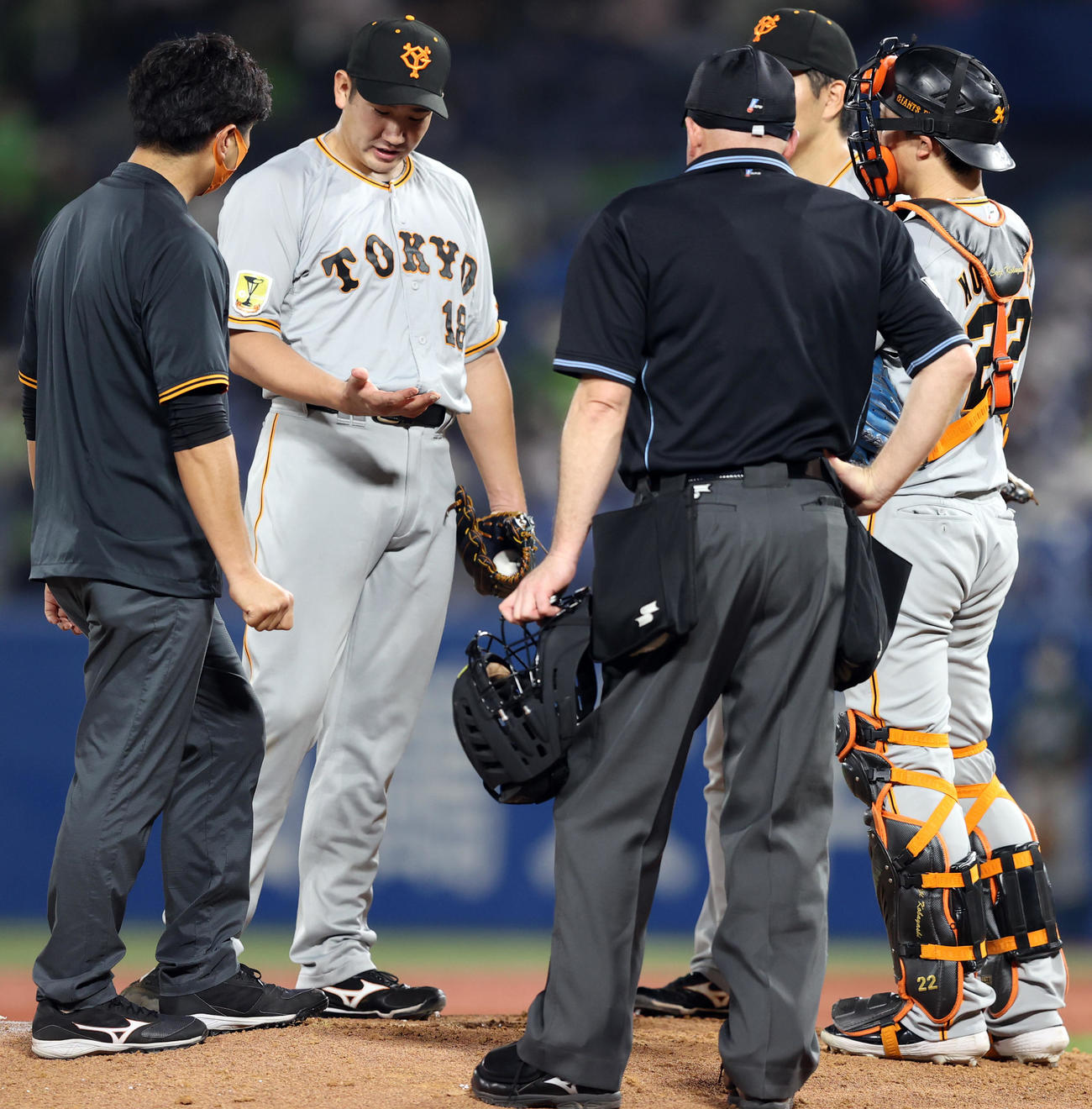 ヤクルト対巨人　7回裏の直前の投球練習後、右手を見つめる菅野。ベンチに戻った後、そのまま降板した（撮影・狩俣裕三）
