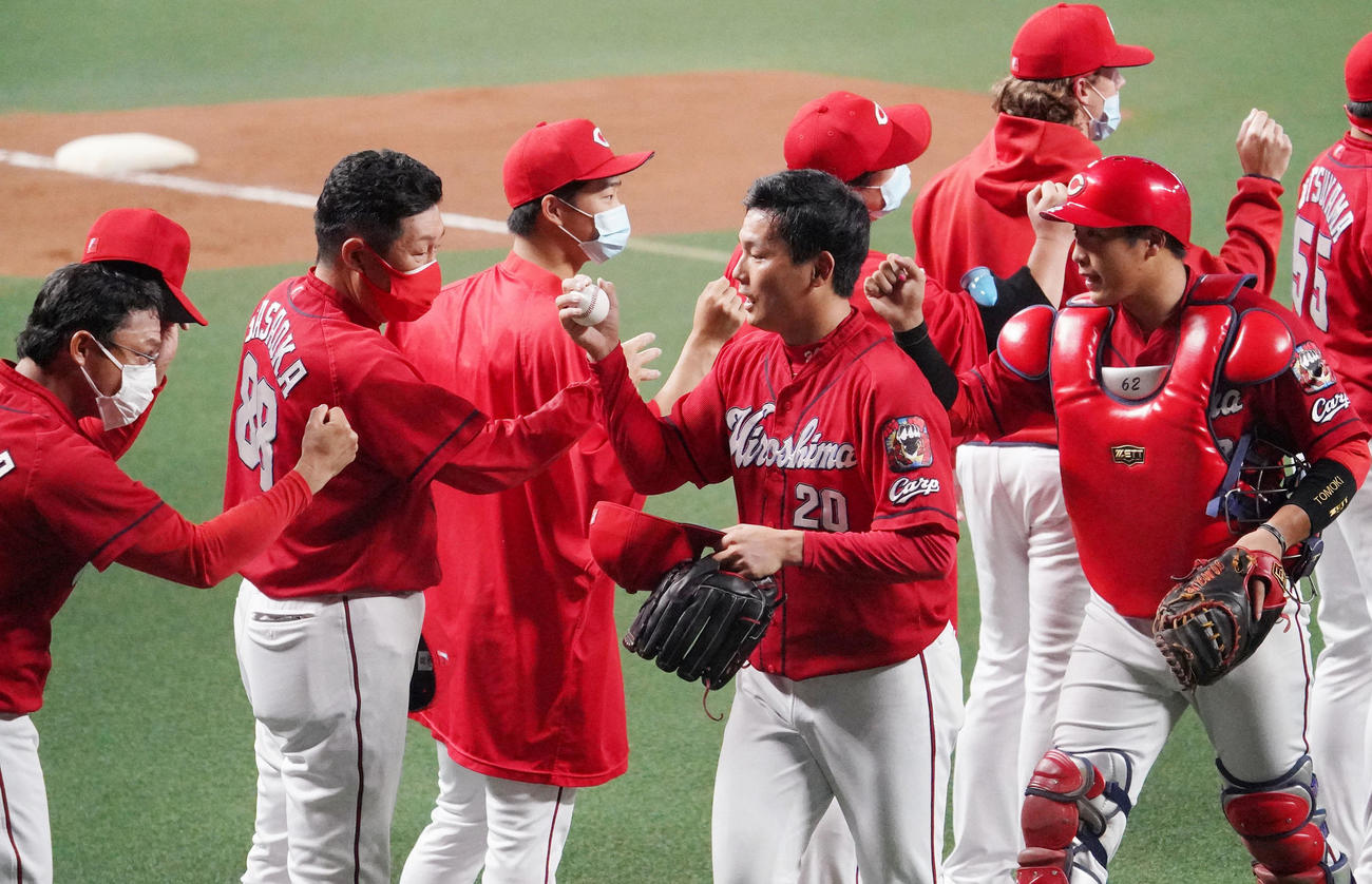 中日対広島　試合終了、30セーブを達成し佐々岡監督らナインとタッチをかわす栗林（中央）（撮影・森本幸一）