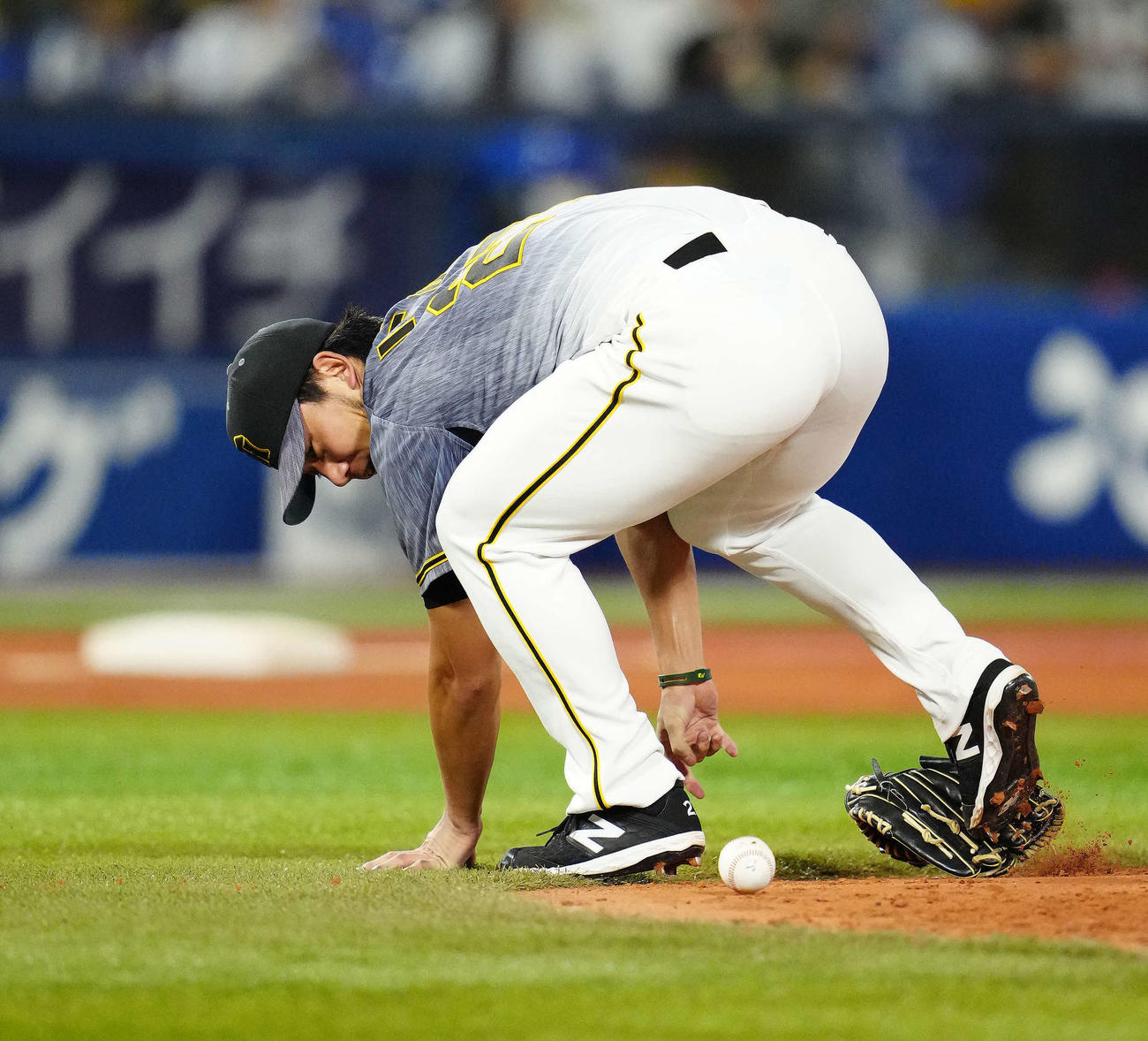 DeNA対阪神　4回裏DeNA無死一塁、宮崎の打球をグラブを落としながら処理するも、一塁へ悪送球し進塁を許した投手伊藤将（撮影・江口和貴）