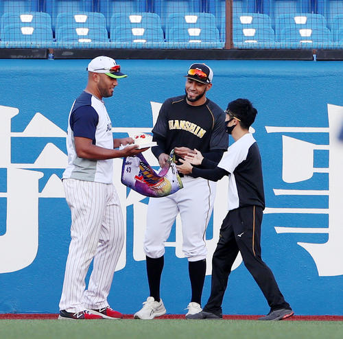 ヤクルト対阪神　バースデーケーキをプレゼントされ笑顔を見せるヤクルトのスアレス。中央は阪神スアレス（撮影・加藤哉）