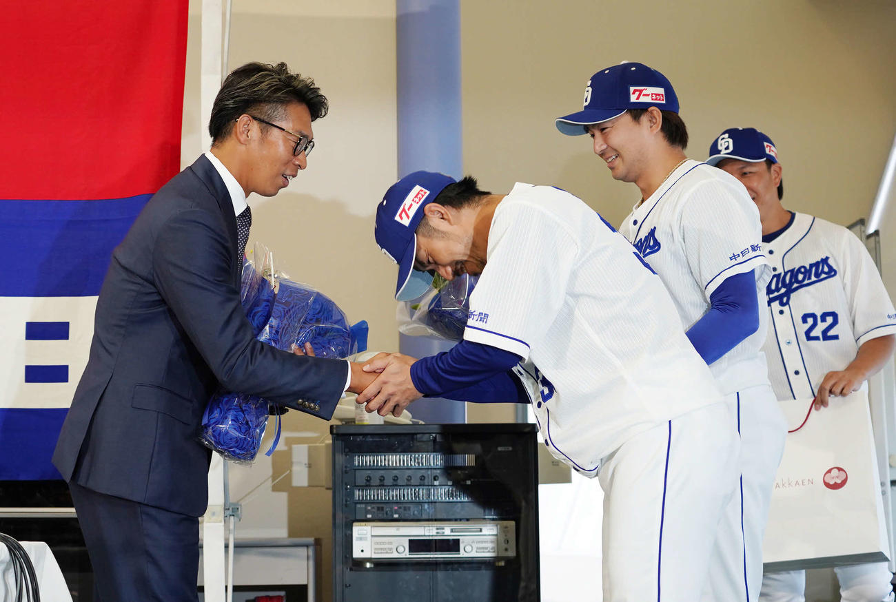引退会見後、（右から）大野雄、田島、祖父江から花束を受け取り握手をかわす山井（左）（撮影・森本幸一）