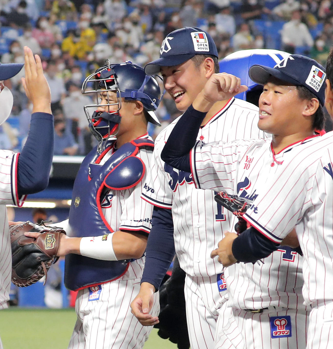 ヤクルト対阪神　7回表を抑えベンチに戻る田口（右）を笑顔で迎える奥川（撮影・河田真司）