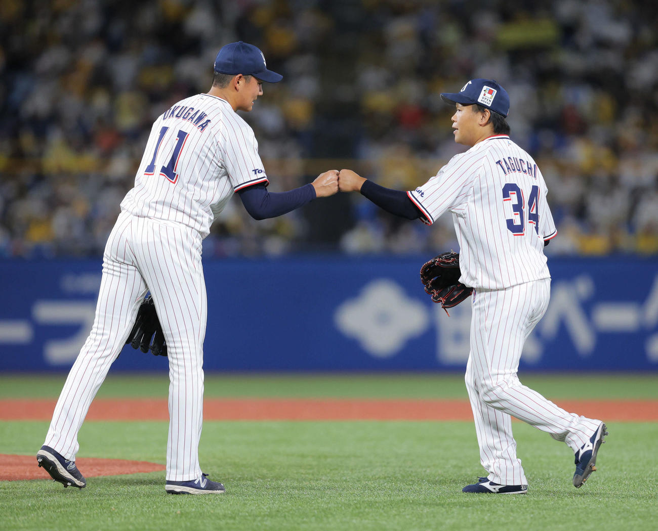 ヤクルト対阪神　7回表阪神2死満塁、降板となり田口（右）とグータッチする奥川（撮影・河田真司）