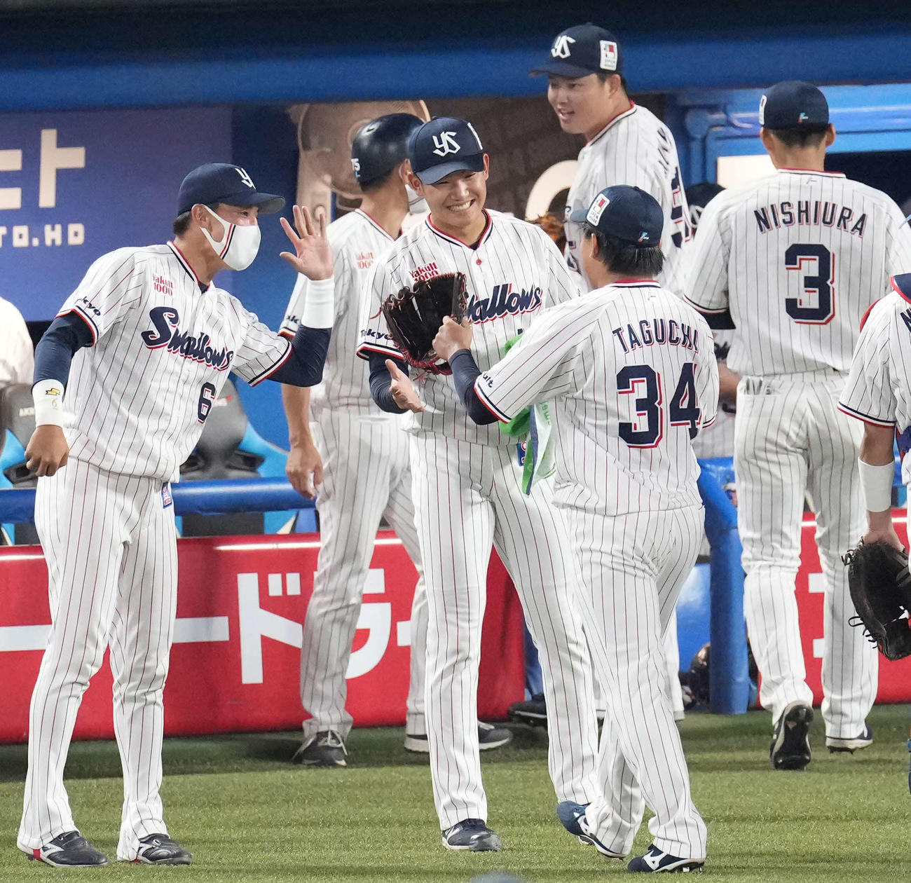 ヤクルト対阪神　7回表阪神2死満塁、代打糸井を空振り三振に仕留めた田口（中央手前）を笑顔で迎える奥川（中央）（撮影・鈴木みどり）