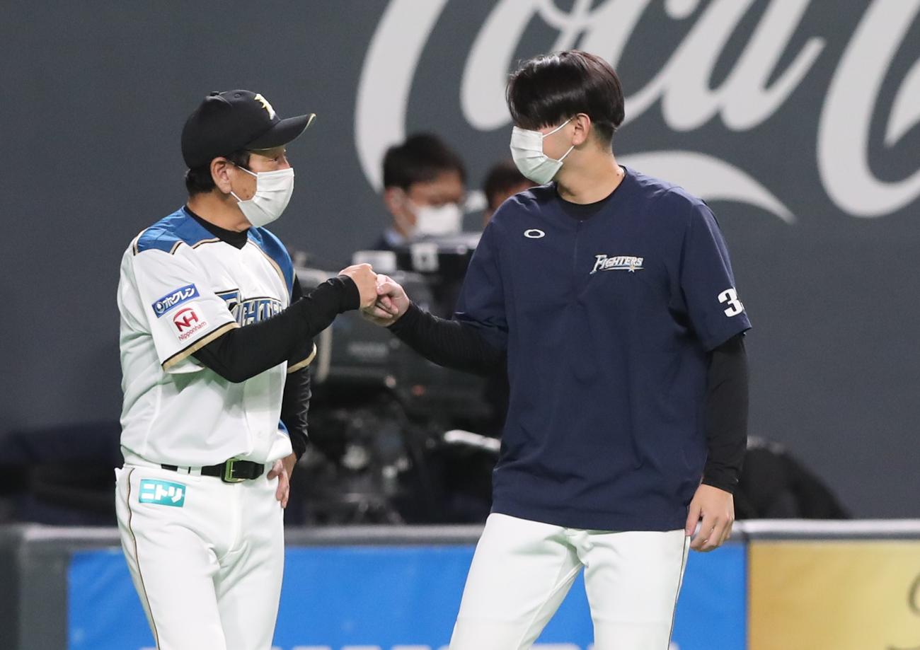 日本ハム対ロッテ　試合後、立野（右）とタッチする栗山監督（撮影・黒川智章）