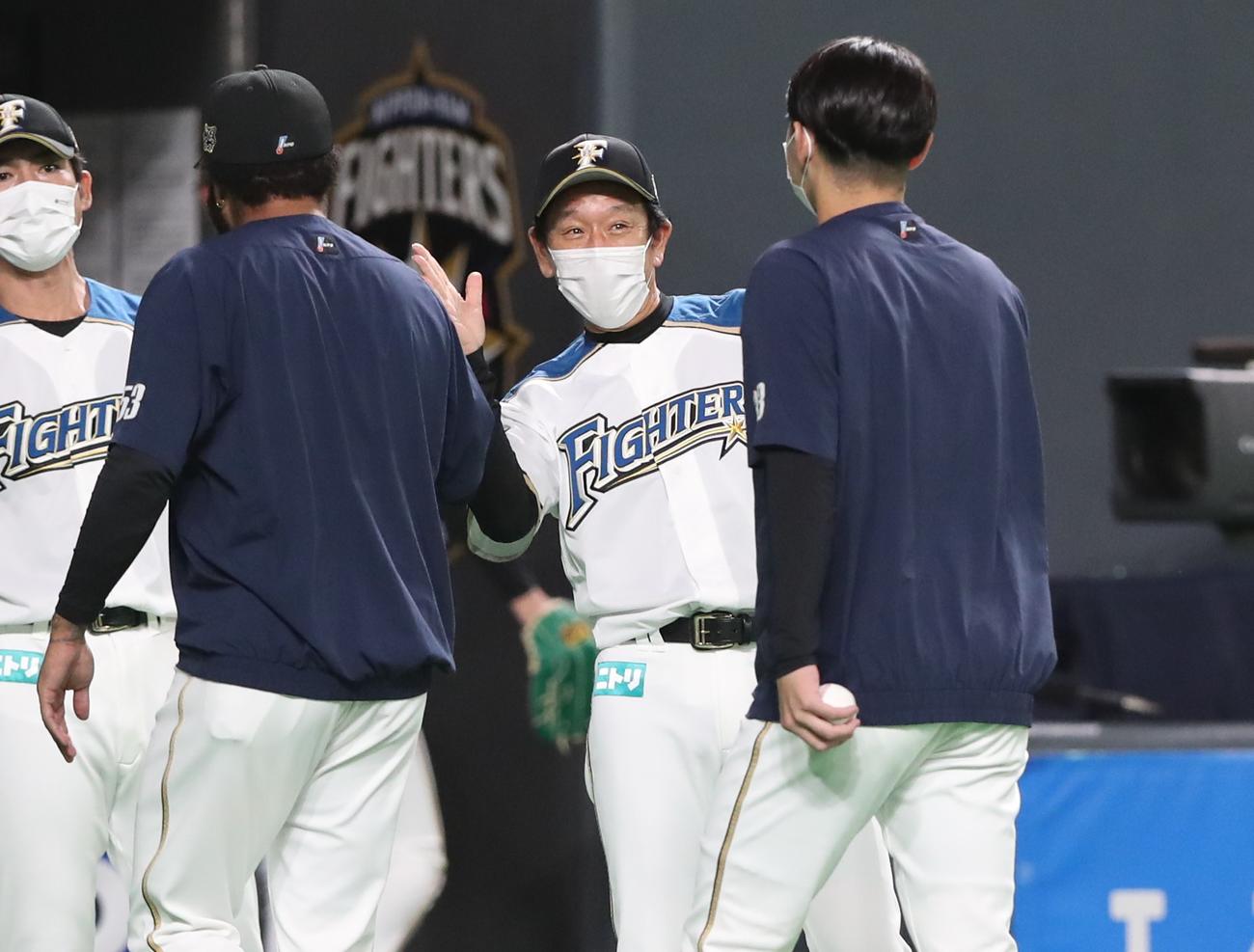 日本ハム対ロッテ　試合後、R・ロドリゲス（左）と立野（右）を笑顔で出迎える栗山監督（撮影・黒川智章）