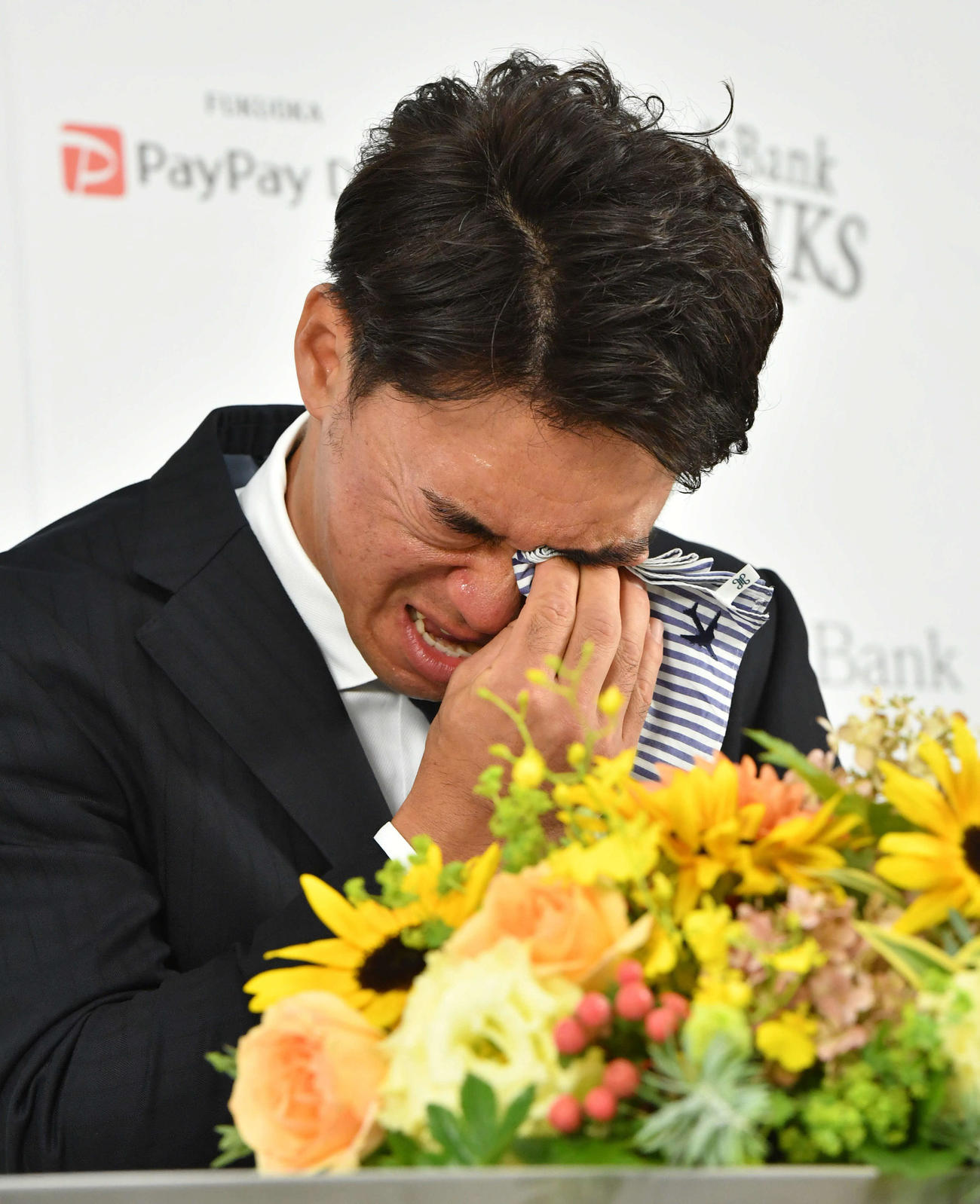 引退会見で涙をぬぐう長谷川（撮影・岩下翔太）