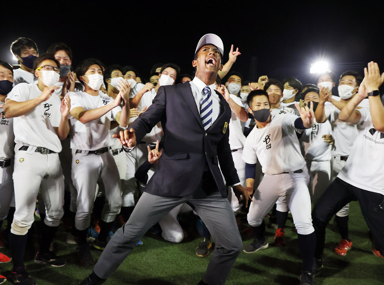 中日1位指名された上武大のブライト（中央）は、野球部員の手拍子の中で武藤敬司の「プロレスLOVE」のポーズを披露（撮影・浅見桂子）