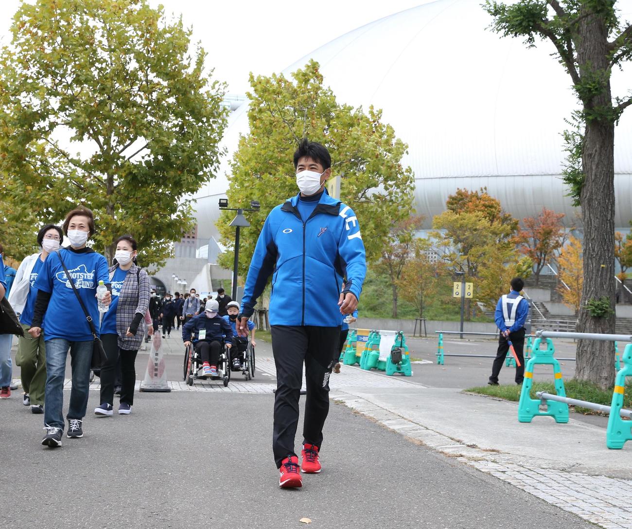 イベント参加者と札幌ドームからさっぽろ羊ケ丘展望台までの往復を歩く稲葉SCO（撮影・黒川智章）