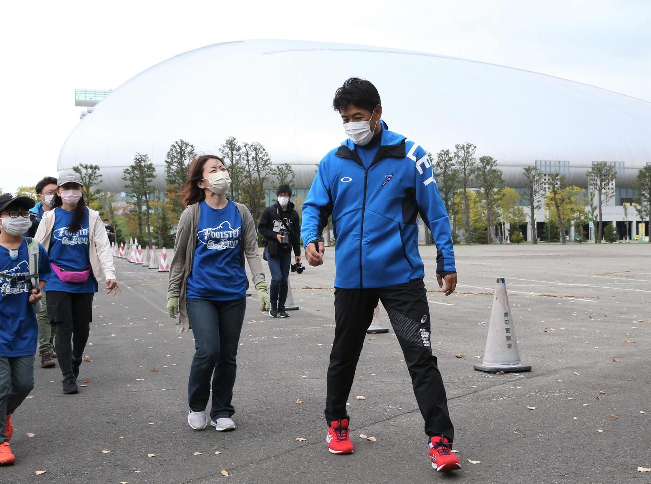 イベント参加者と札幌ドームからさっぽろ羊ケ丘展望台までの往復を歩く稲葉SCO（撮影・黒川智章）