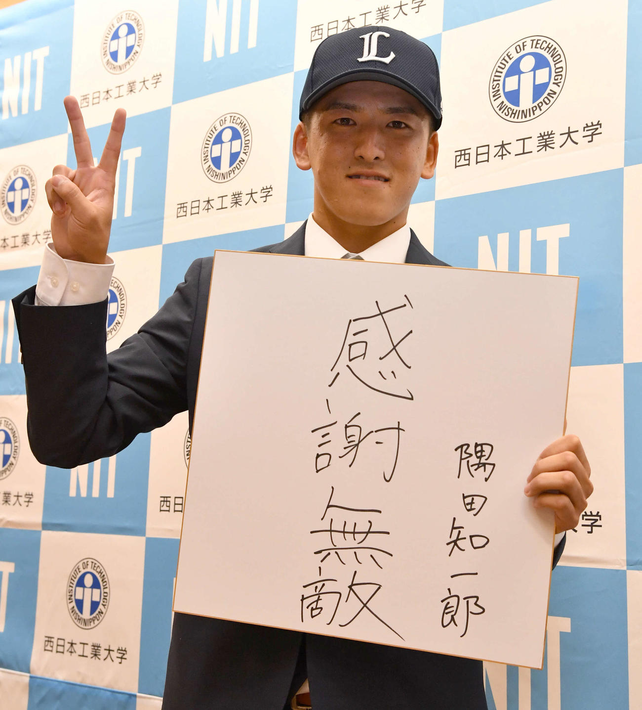 色紙に好きな言葉の「感謝無敵」を記してピースサインを見せる西日本工大・隅田（撮影・岩下翔太）