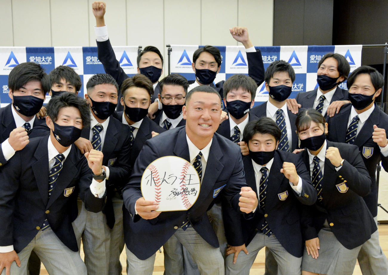 楽天から2位指名を受け、ポーズをとる愛知大の安田悠馬捕手（前列中央）（共同）