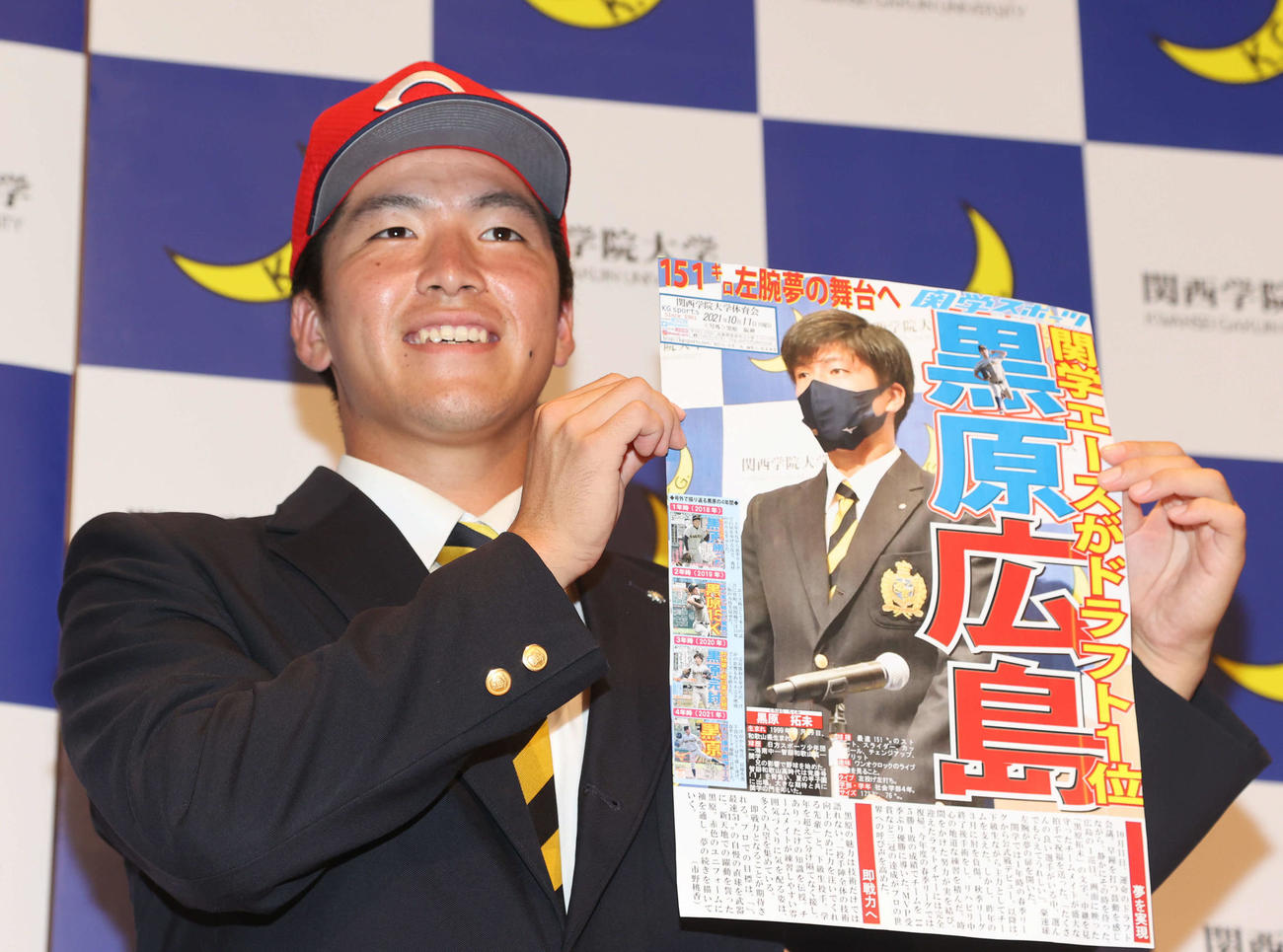 関学スポーツの号外を手に笑顔の関学大・黒原（撮影・渦原淳）