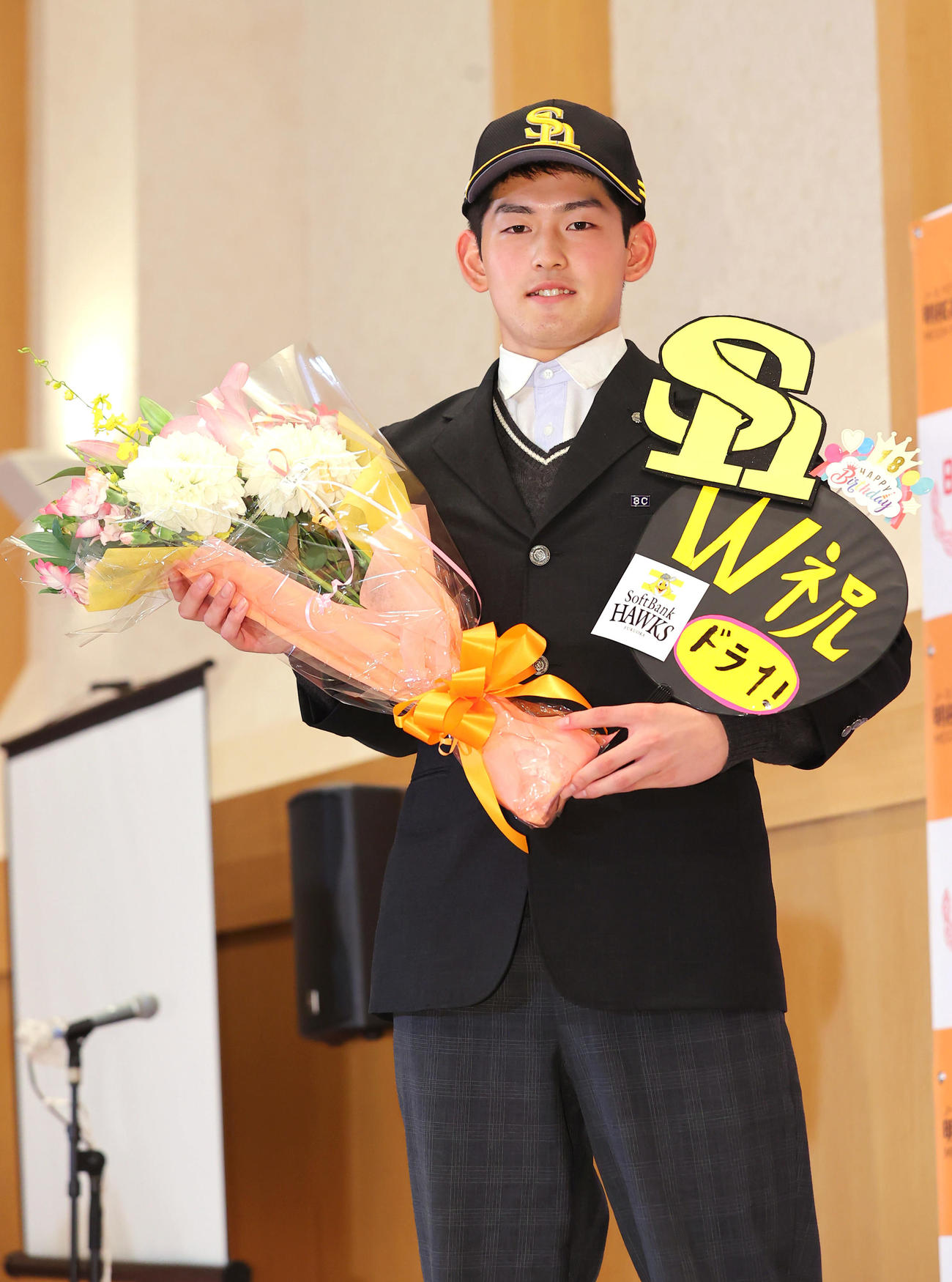 ソフトバンクの1位指名を受けこの日誕生日のノースアジア大明桜・風間は贈られた花束を手に笑顔で写真に納まる（撮影・垰建太）