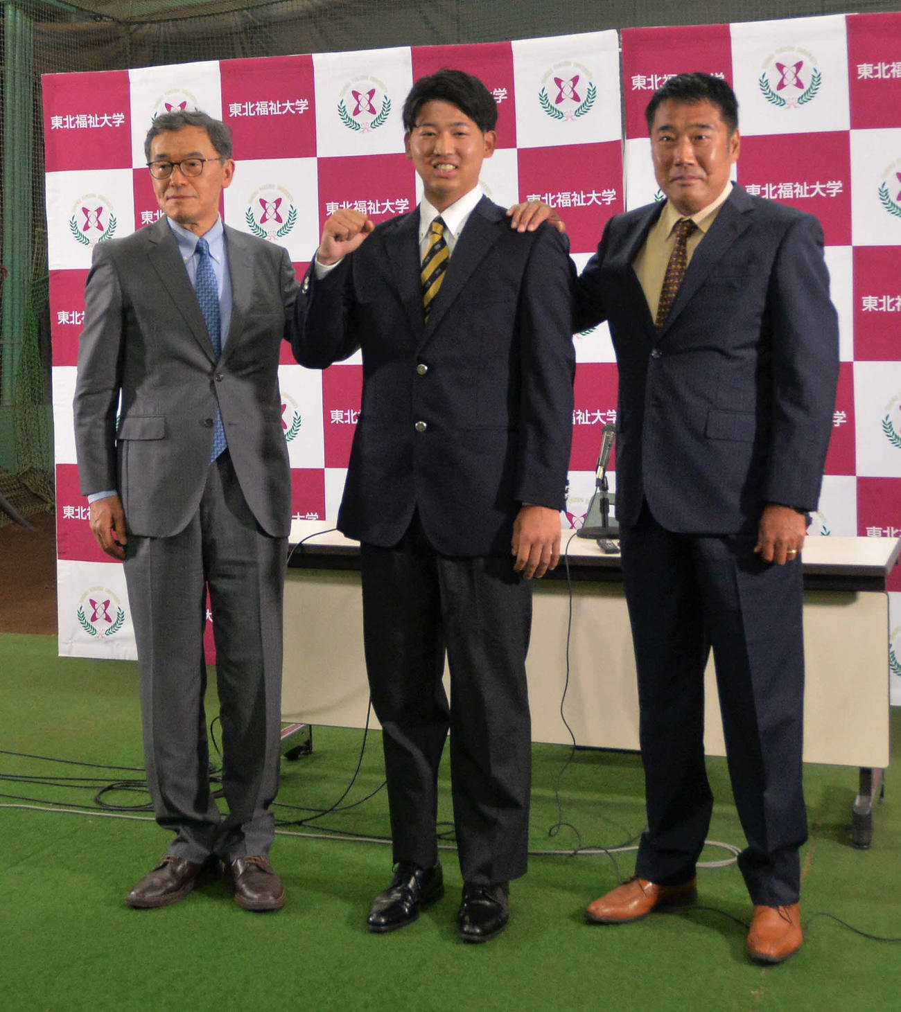 オリックスから1位指名を受けて笑顔を見せる東北福祉大・椋木（中央）。左は寺下部長、右は大塚監督（撮影・佐藤究）