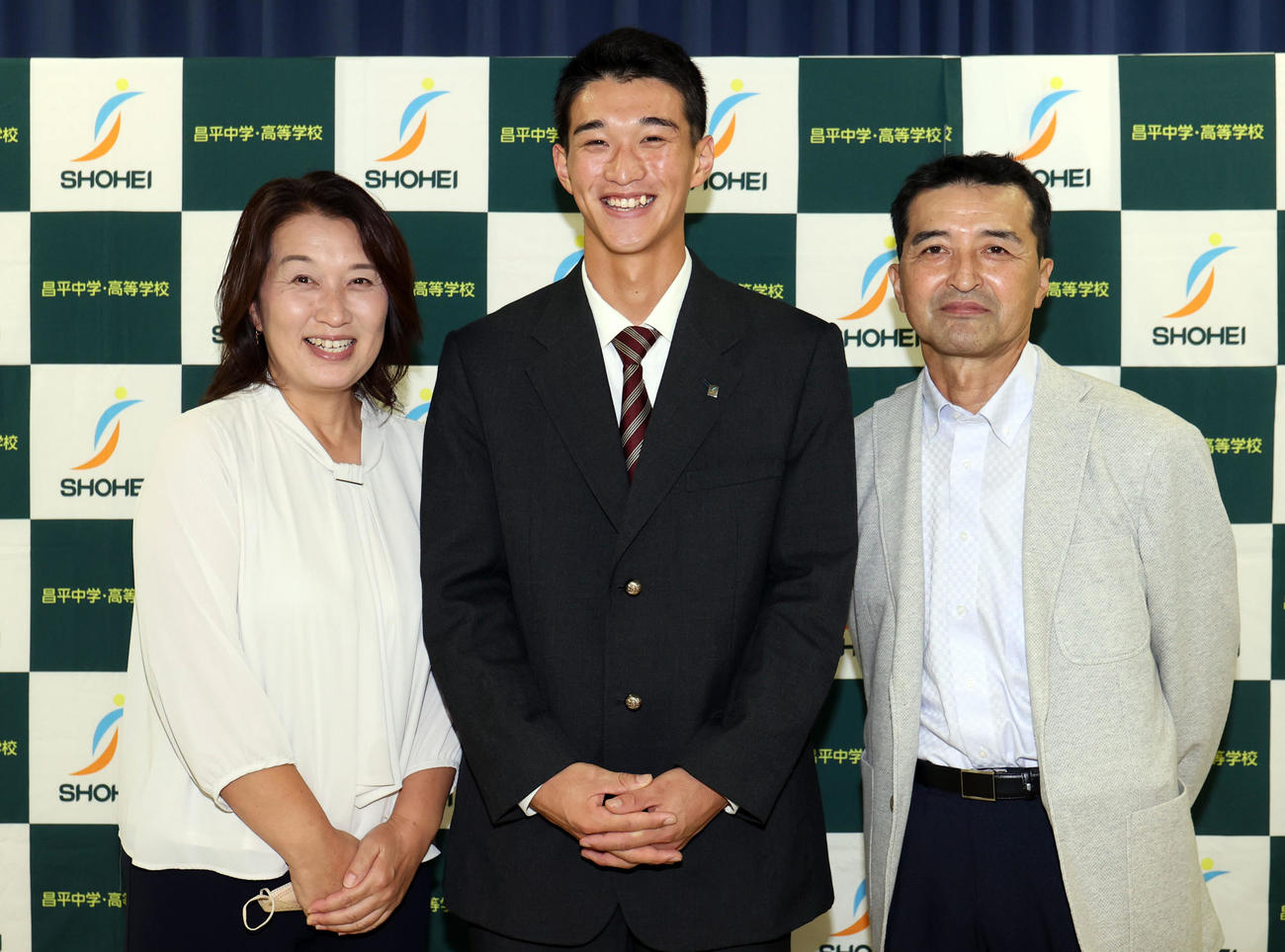 楽天ドラフト1位で指名され、母智子さん（左）、父善規さん（右）と記念撮影をする昌平高・吉野（撮影・狩俣裕三）