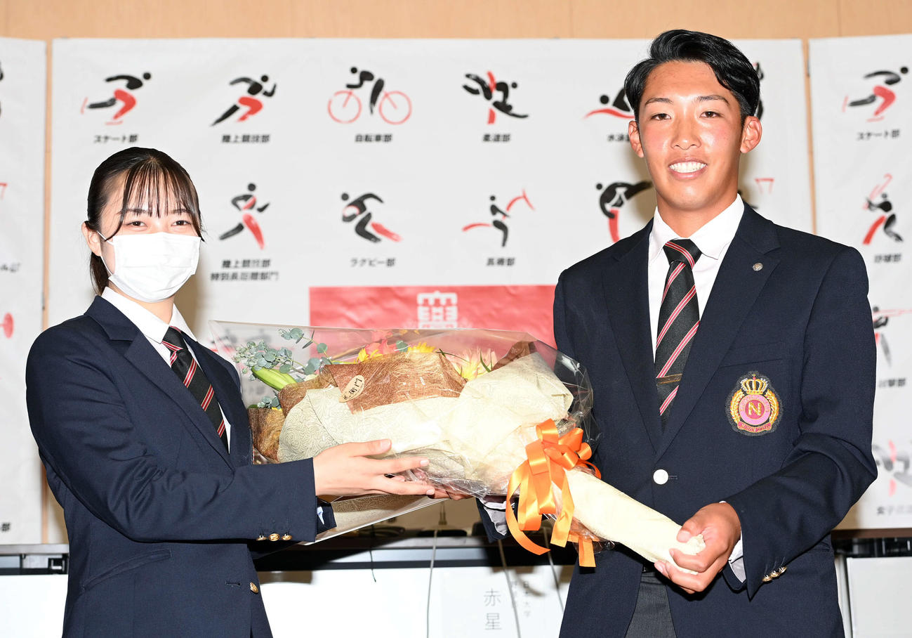 巨人から3位指名を受けた日大赤星は、花束を受け取り笑顔を見せる（撮影・たえ見朱実）
