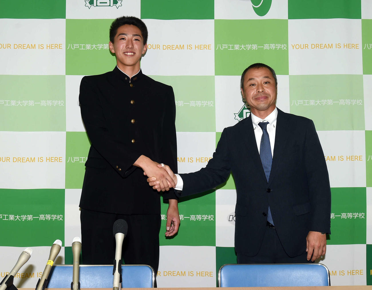 握手をかわす八戸工大一・黒田（左）と長谷川監督