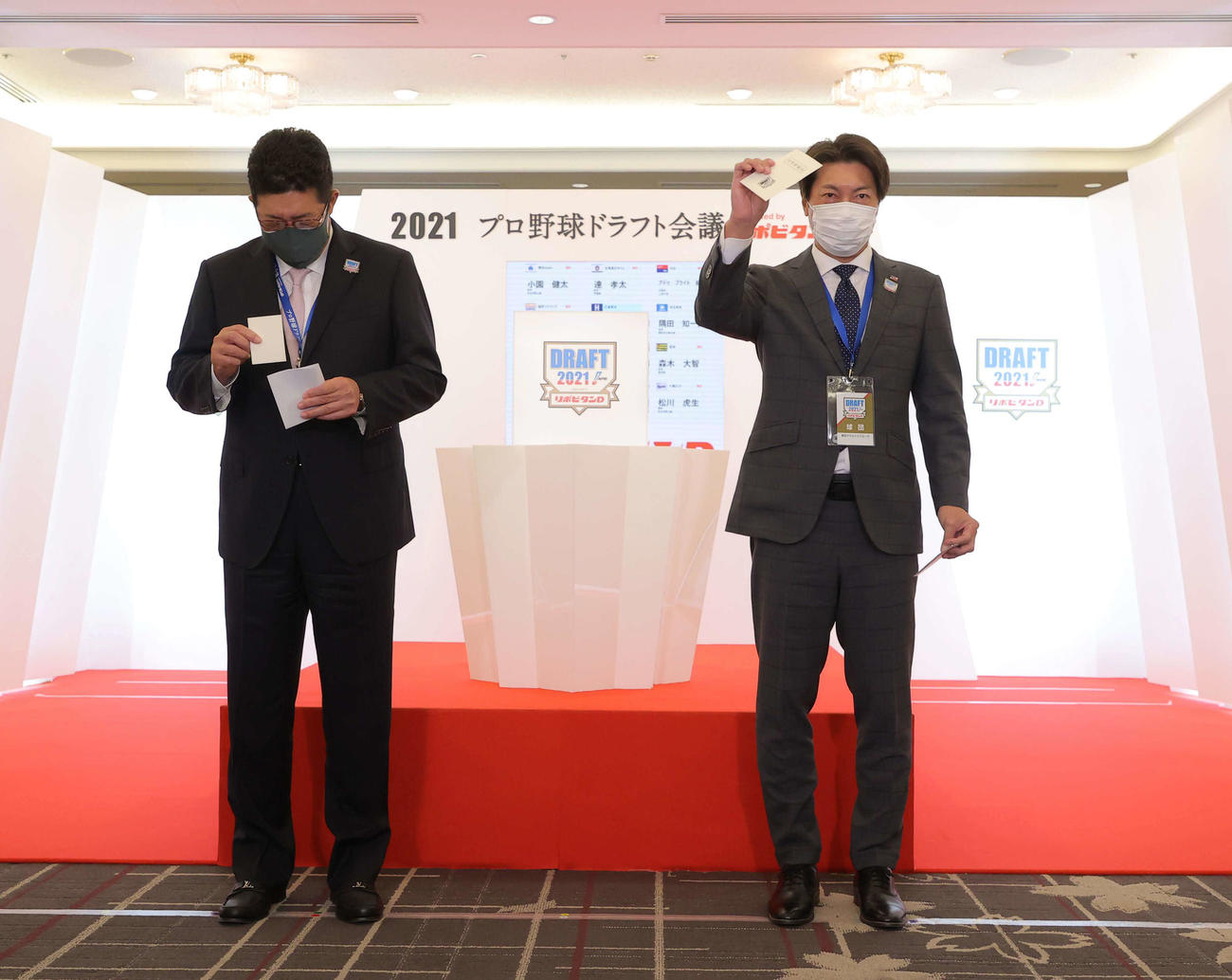 1位指名で法大山下の交渉権を獲得したヤクルト高津監督は当たりくじを掲げる。左は広島佐々岡監督（代表撮影）