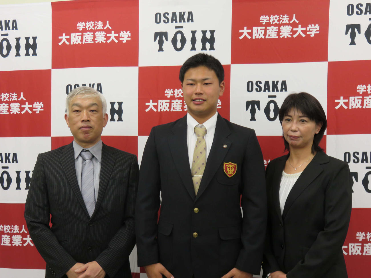 日本ハムからドラフト7位指名を受け、父親吉仁さん、母親美雅さんと記念撮影する大阪桐蔭・松浦
