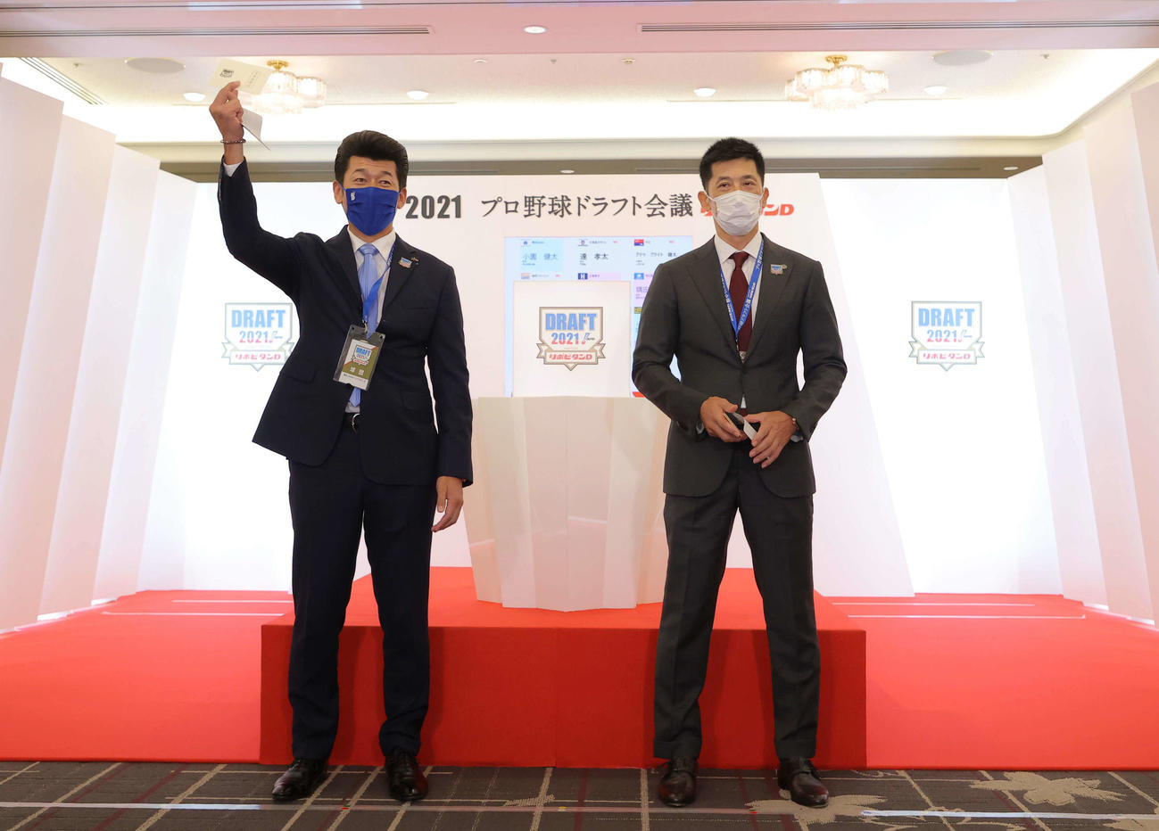 1位指名で市和歌山・小園健太の交渉権を獲得したDeNA三浦監督は当たりくじを掲げる。右は阪神矢野監督（代表撮影）