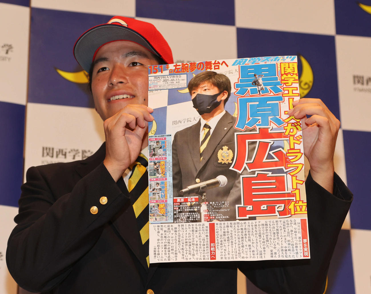 関学スポーツの号外を手に笑顔の関学大・黒原拓未（撮影・渦原淳）