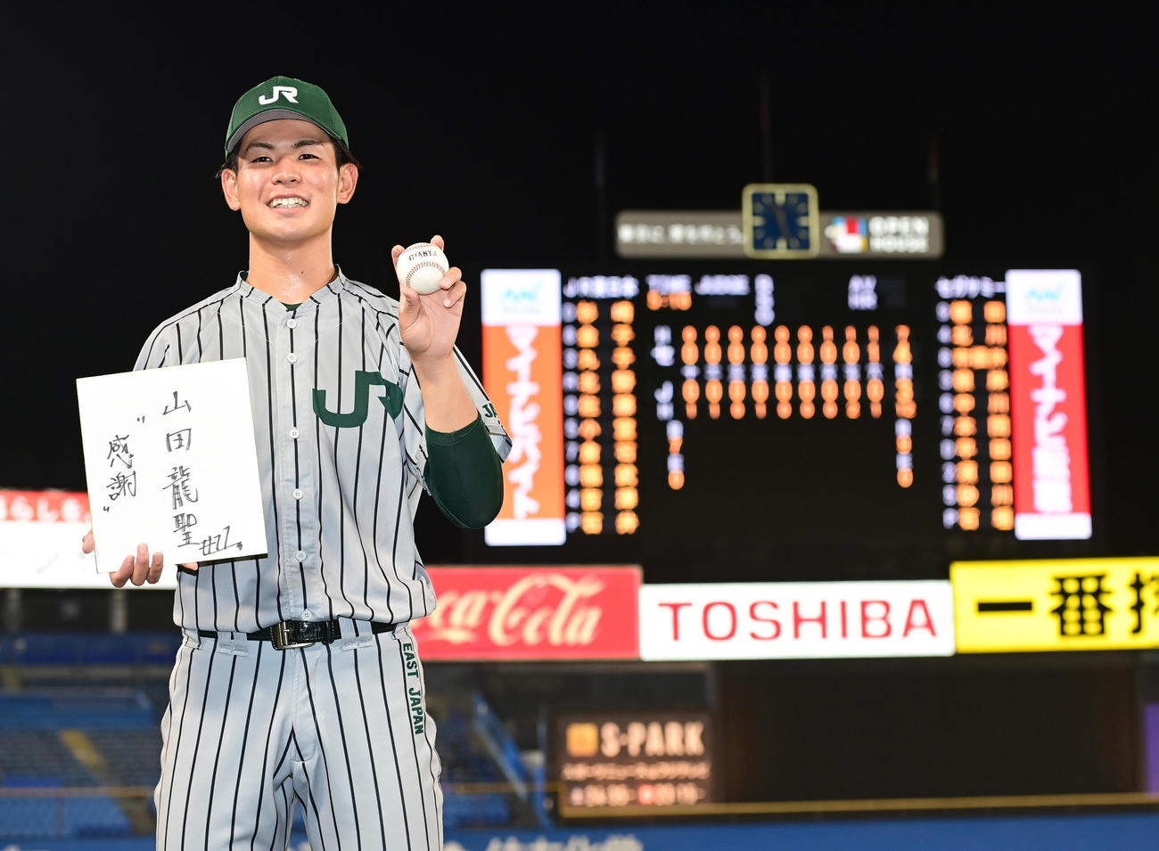延長18回の激闘の末にセガサミーに敗れたJR東日本・山田は、ドラフト2位指名を受けての会見を試合後に臨み、色紙を手に笑顔を見せる（撮影・小沢裕）