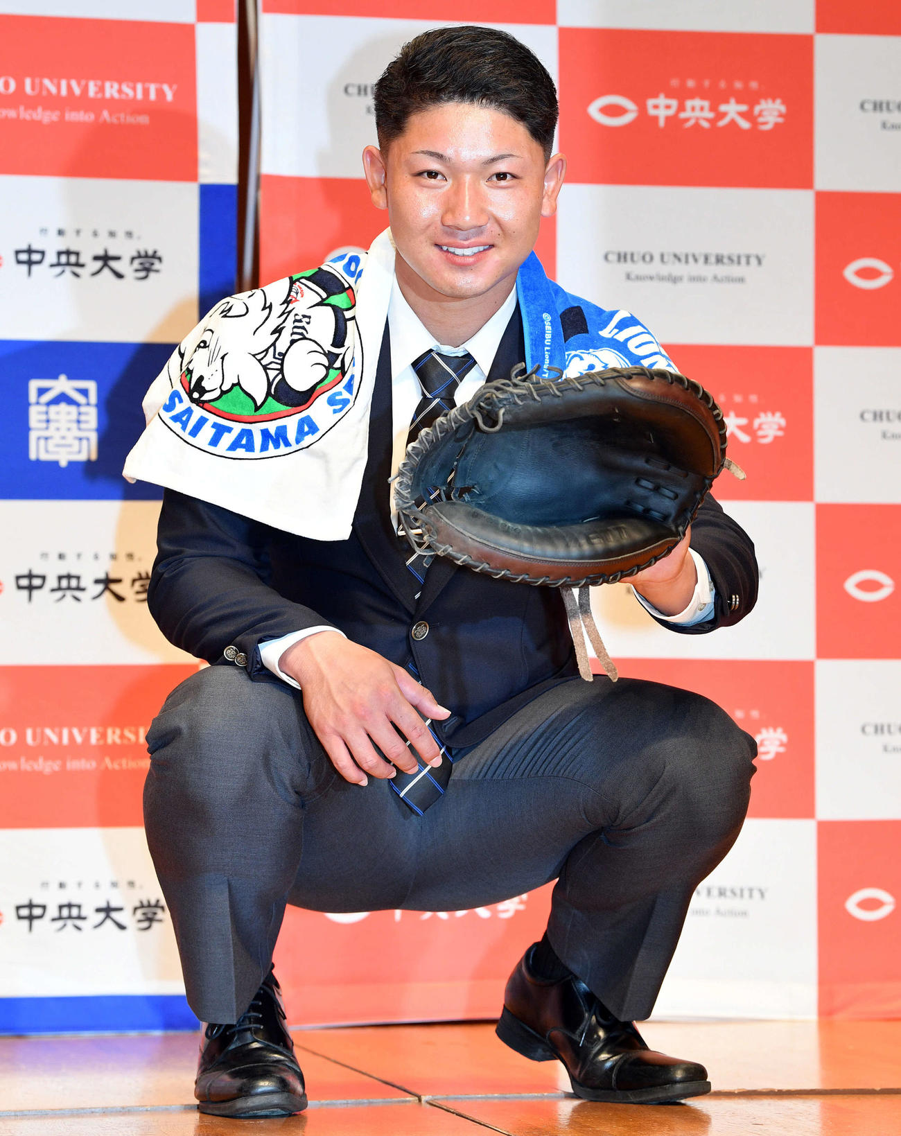 西武からドラフト3位で指名された中大・古賀はキャッチャーミットをはめポーズを決める（撮影・滝沢徹郎）
