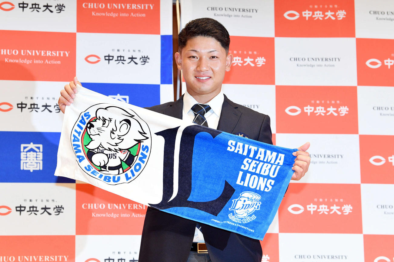 西武からドラフト3位で指名された中大・古賀はタオルを手に笑顔で記念撮影する（撮影・滝沢徹郎）
