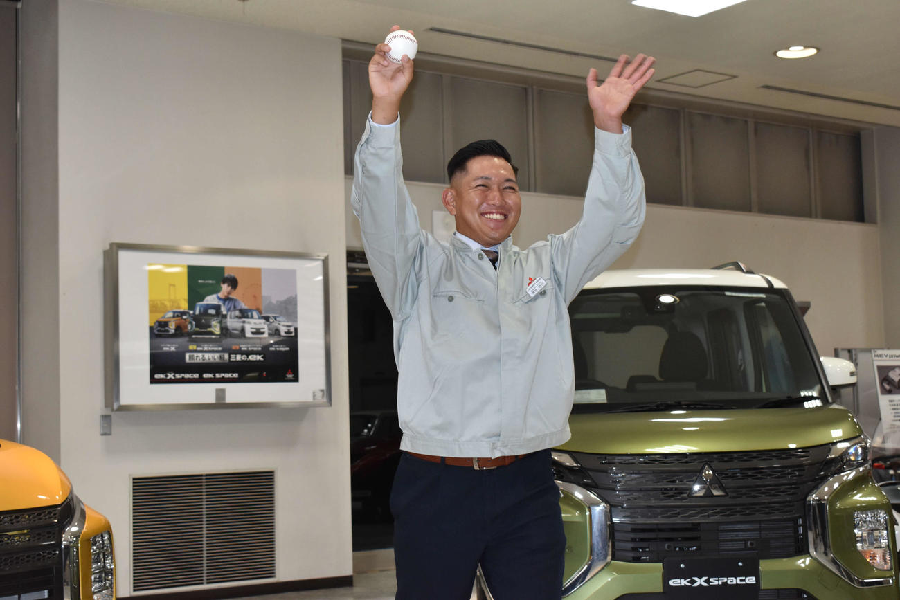 三菱自動車をバックに、笑顔で写真撮影に応じるロッテ3位に指名された三菱自動車倉敷オーシャンズ・広畑（撮影・古財稜明）