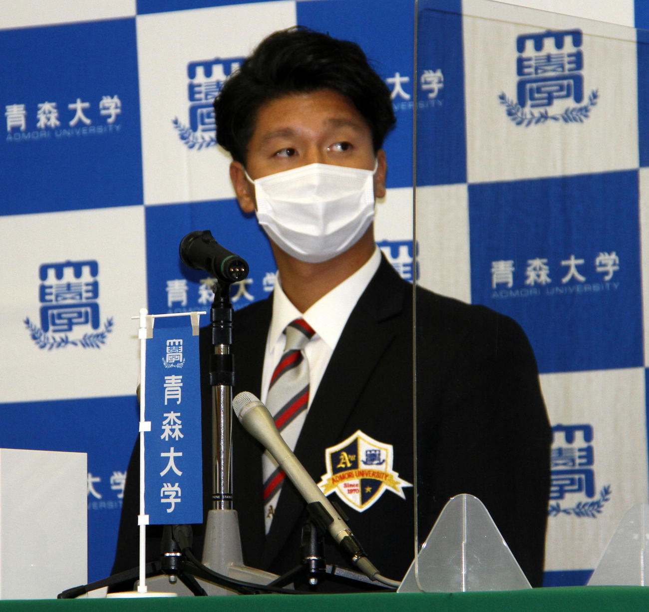 ドラフト会議のテレビ画面に目をやる青森大・長谷川