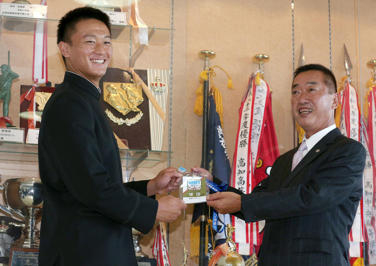 阪神ドラフト1位の高知・森木（左）は山本スカウトから矢野監督の直筆サイン入りのドラフト会議入館パスを笑顔で受け取る（撮影・上山淳一）