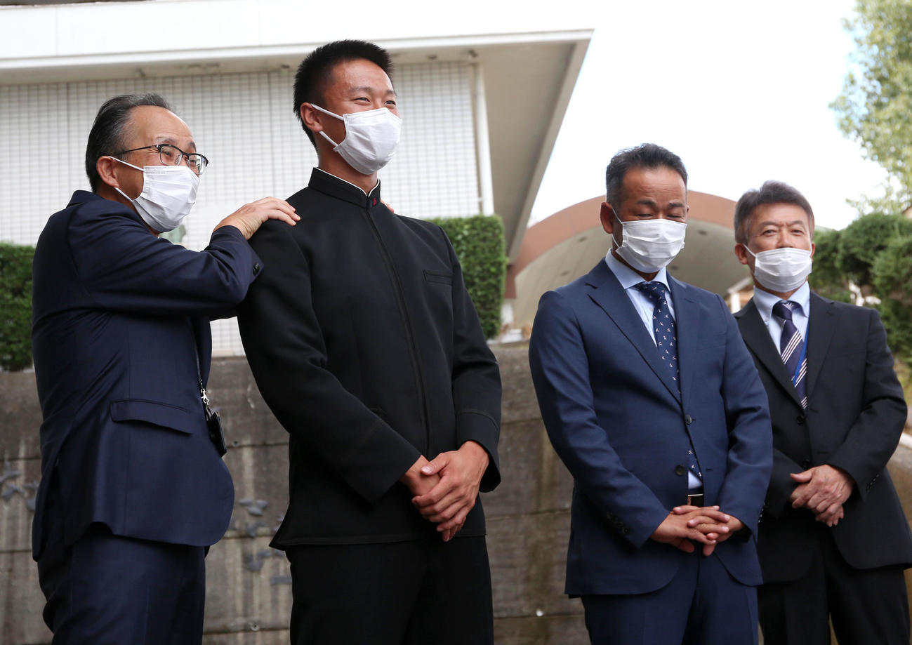 高知・永野校長（左）は緊張の面持ちで阪神スカウトらの到着を待つ森木（左から2人目）の肩をもんでリラックスさせる。右から2人目は浜口監督、右は久保部長（撮影・上山淳一）