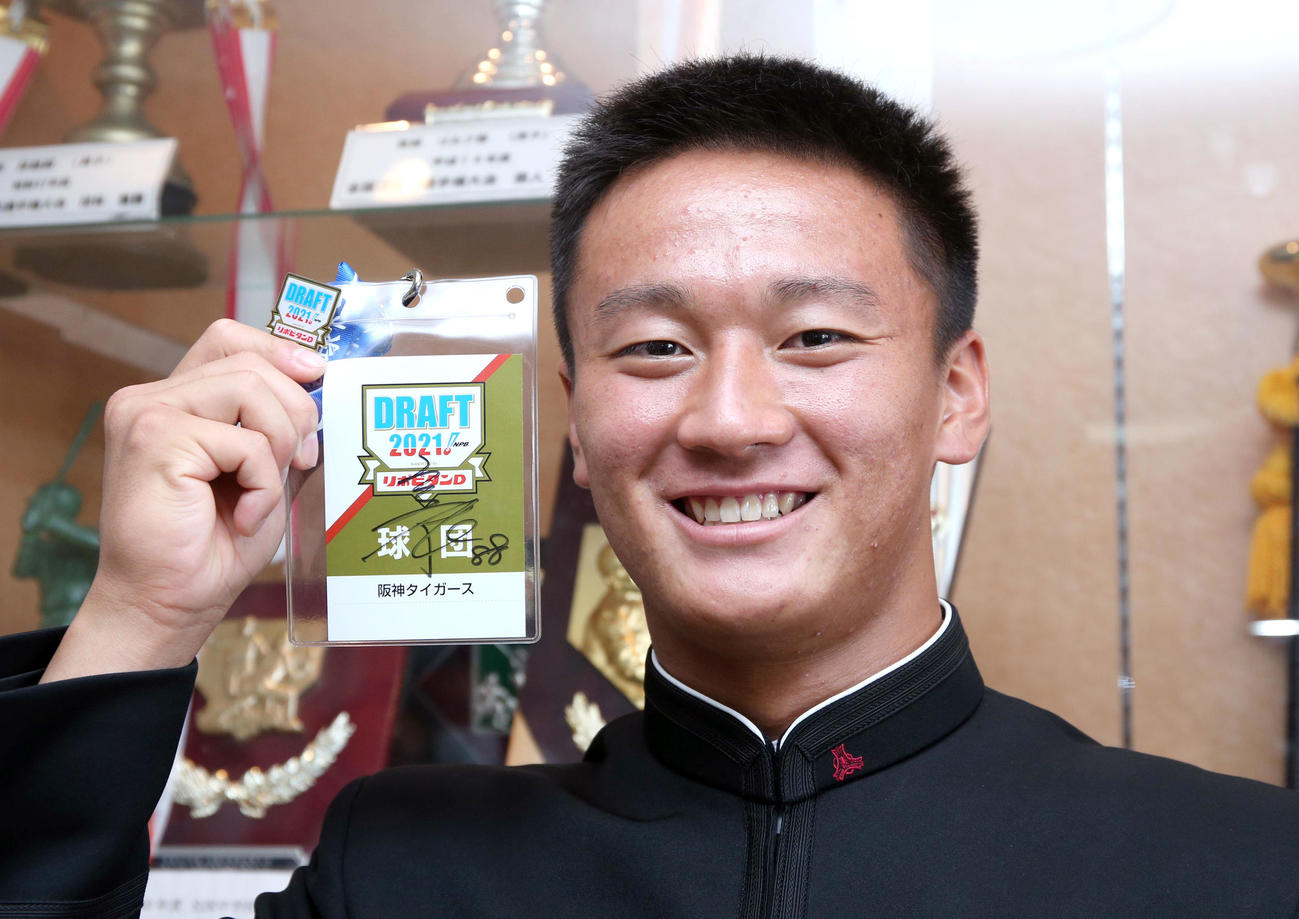 阪神ドラフト1位の高知・森木は矢野監督の直筆サイン入りのドラフト会議入館パス持って笑顔を見せる（撮影・上山淳一）