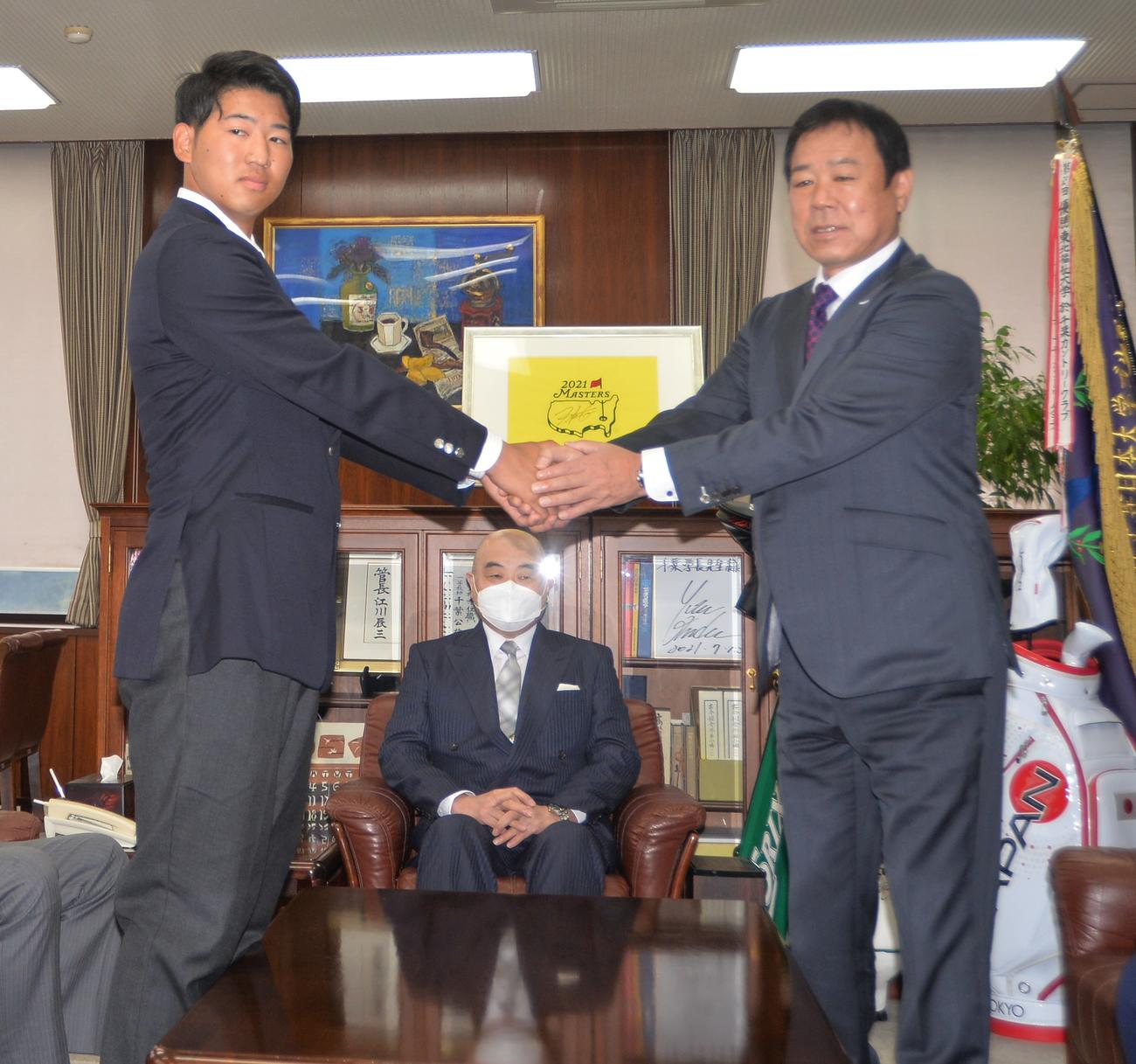 指名あいさつに臨んだオリックス1位指名の東北福祉大・椋木（左）は福良GM（右）と握手を交わす（撮影・佐藤究）