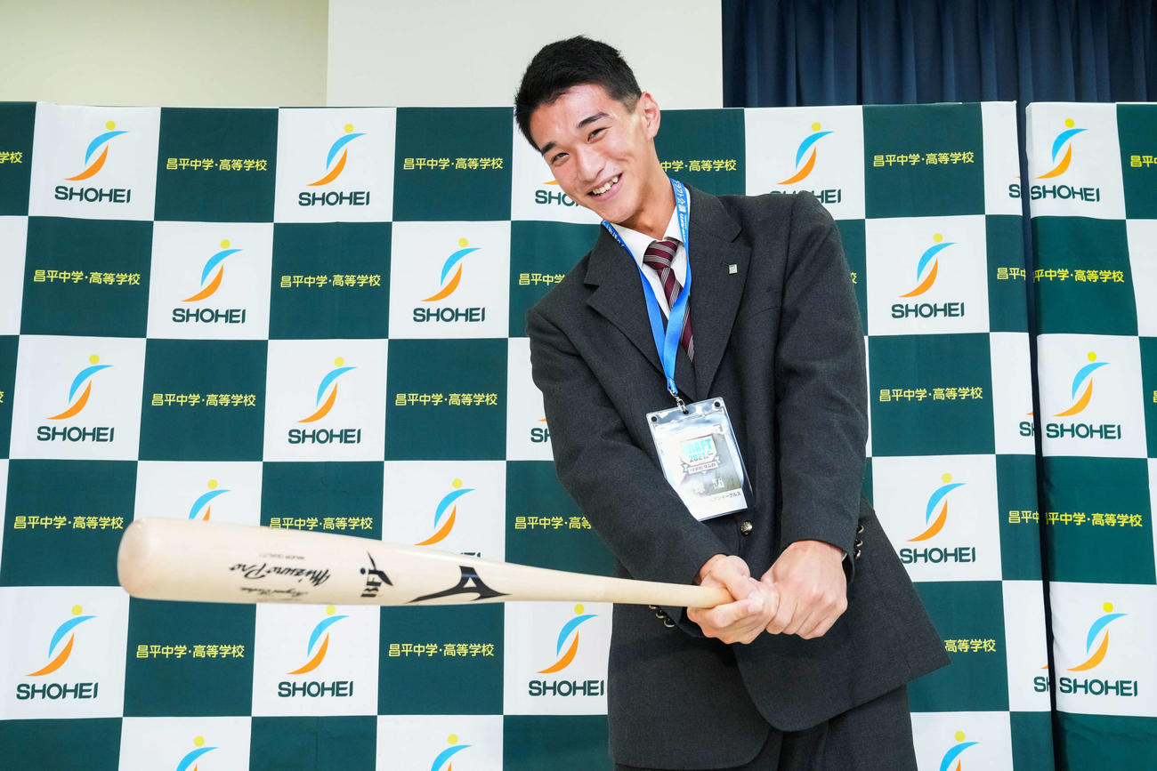楽天からドラフト1位指名を受けた昌平・吉野は、楽天石井GM兼監督が直筆サインしたドラフト会議のIDパスを首に、バットを持ってポーズをする