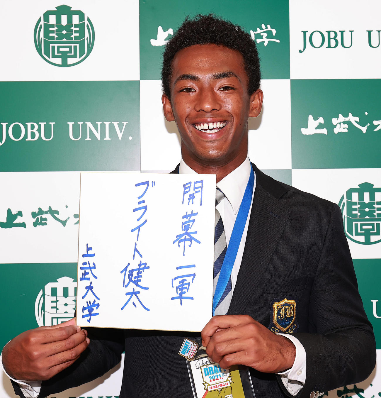 中日ドラフト1位の上武大・ブライトは、指名あいさつを終えると笑顔で色紙に「開幕一軍」と記した（撮影・野上伸悟）