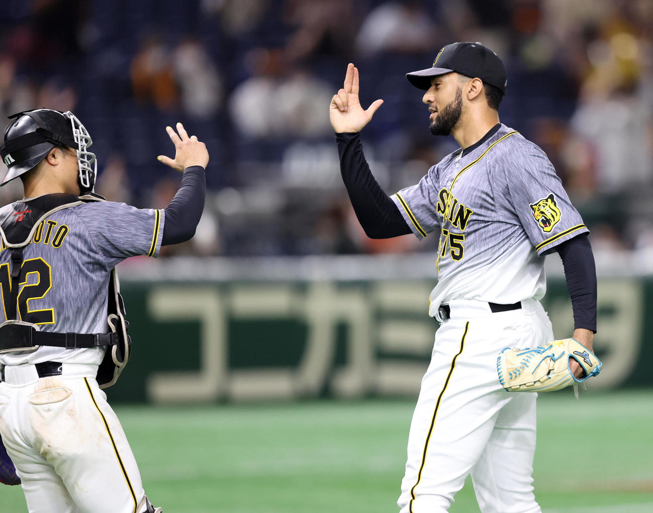 巨人対阪神　試合後、坂本（左）と勝利を喜び合うスアレス（撮影・狩俣裕三）